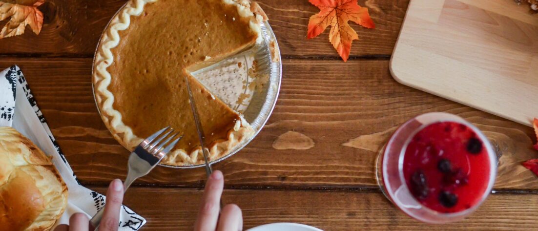 person slicing pumpkin pie