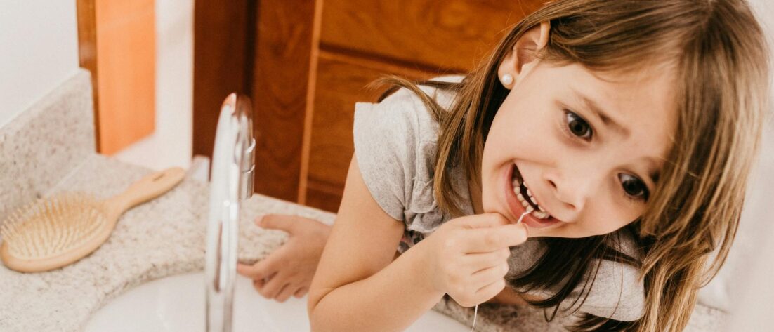 a girl flossing her teeth
