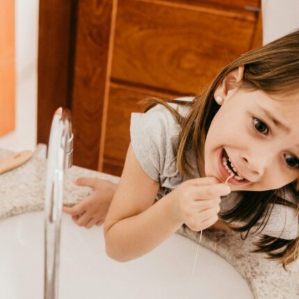 a girl flossing her teeth
