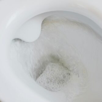 flushing water in white toilet bowl