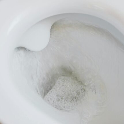flushing water in white toilet bowl