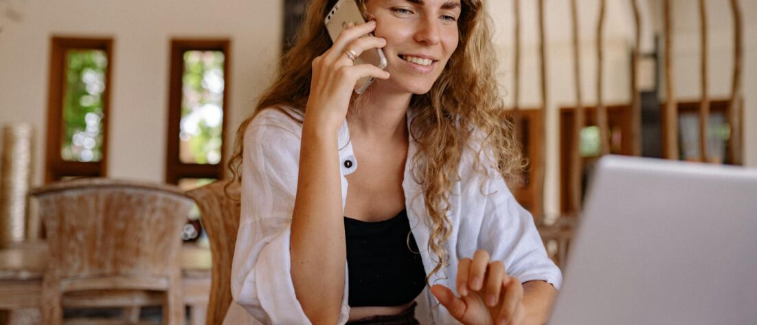 photo of woman using cellphone while smiling