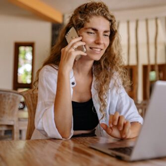 photo of woman using cellphone while smiling